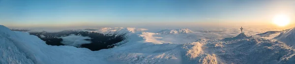 Nieve cubierto de montañas panorama. Amanecer. Cruz esmerilada en la parte superior —  Fotos de Stock