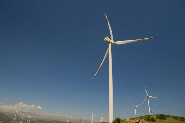 Wind power stations agaisnt blue sky background