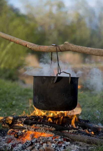 Siyah tencere ateş altında ısınıyor