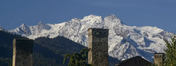 Panorama-Svaneti torn mot snötäckta berg — Stockfoto