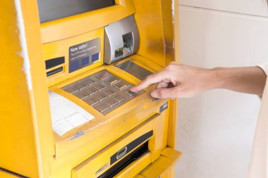 Para çekmek için ATM 'nin pin tuşuna kadın eli basarak şifre bankasını kapat