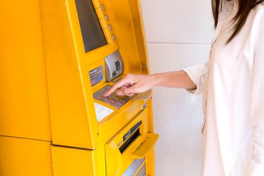 Para çekmek için ATM 'nin pin tuşuna kadın eli basarak şifre bankasını kapat