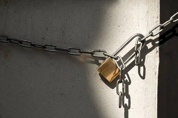 Padlock and chain isolated on wall background