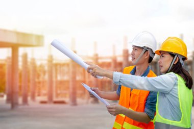 Mühendis, inşaat alanlarını denetliyor ve şehir merkezi projesinin planlarını kontrol ediyor.