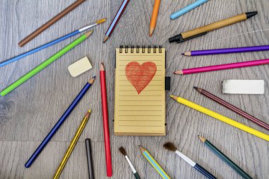 Ahşap arka planda dizüstü bilgisayar lı renkli kalemler