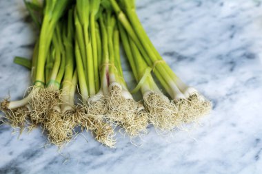 Mermer mutfak tezgah üzerinde yeşil taze sarımsak