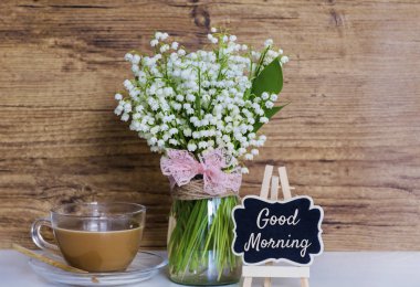 Lila ile çalar saat, sabah kahve ve iyi metin ahşap arka plan üzerinde bir buket. Bahar sabah kavramı