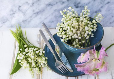 Bahar sofra Vintage mavi çatal bıçak takımı, Lily vadi çiçek ve üzerinde bir mermer Background.Floral Masa desenli pembe lale