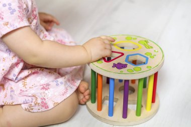 Ahşap eğitici oyuncak ile oynarken tanınmaz halde bebek kız