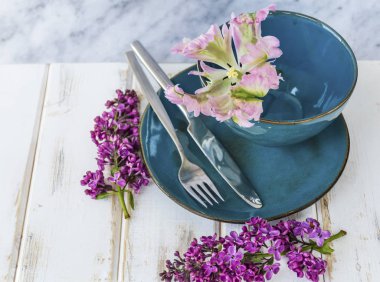 Bahar sofra Vintage mavi çatal bıçak takımı, Lila çiçek ve üzerinde bir mermer Background.Floral Masa desenli pembe lale