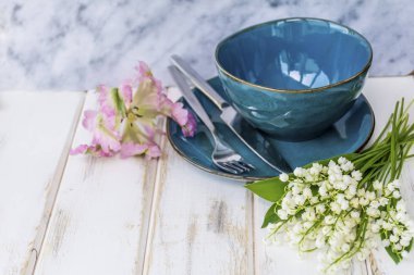 Bahar sofra Vintage mavi çatal bıçak takımı, Lily vadi çiçek ve üzerinde bir mermer Background.Floral Masa desenli pembe lale
