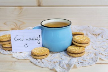 Mavi bardak çay ve kurabiye ahşap tablo