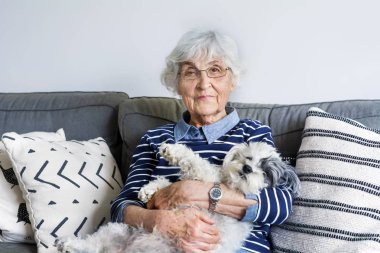 Mutlu kadın kıdemli onun kaniş köpek evde sarılma.