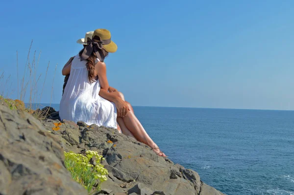 Vista Trasera Pareja Sentada Acantilado Rocoso Cerca Del Mar Azul —  Fotos de Stock