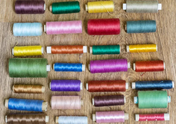 Multi Colored Thread Yarns Frame on Wooden Background
