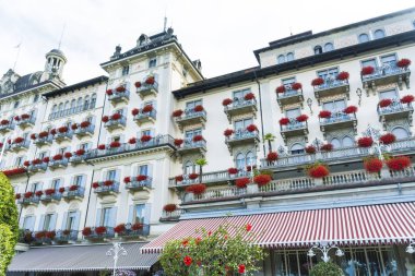 Stresa, Lake Maggiore, İtalya-Haziran 25,2018: Grand Hotel Des Iles Borromees Sardunya çiçekli bol bol çiçek açan Windows ile