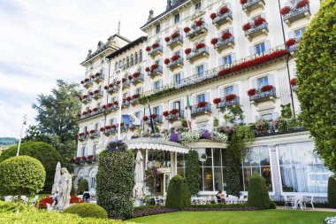 Stresa, Lake Maggiore, İtalya-Haziran 25,2018: Grand Hotel Des Iles Borromees Sardunya çiçekli bol bol çiçek açan Windows ile