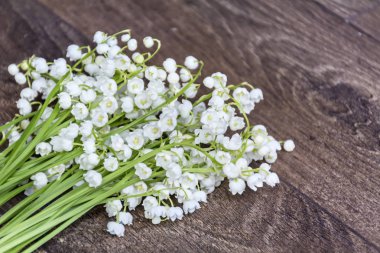 Ahşap arka plan üzerinde pembe kurdele ile Lily vadi buket. Bahar çiçekleri arka plan