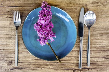 Bir Ahşap Background.Floral Masa desenli sofra Vintage mavi çatal ve Lila çiçeklerle bahar