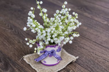 Lily vadi buket kurdele ile vazoda. Bahar çiçekleri arka plan