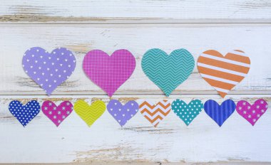 Beyaz ahşap arka plan üzerinde renkli kağıt kalp tebrik kartı