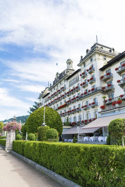 Stresa, Lake Maggiore, İtalya-Haziran 25,2018: Grand Hotel Des Iles Borromees Sardunya çiçekli bol bol çiçek açan Windows ile