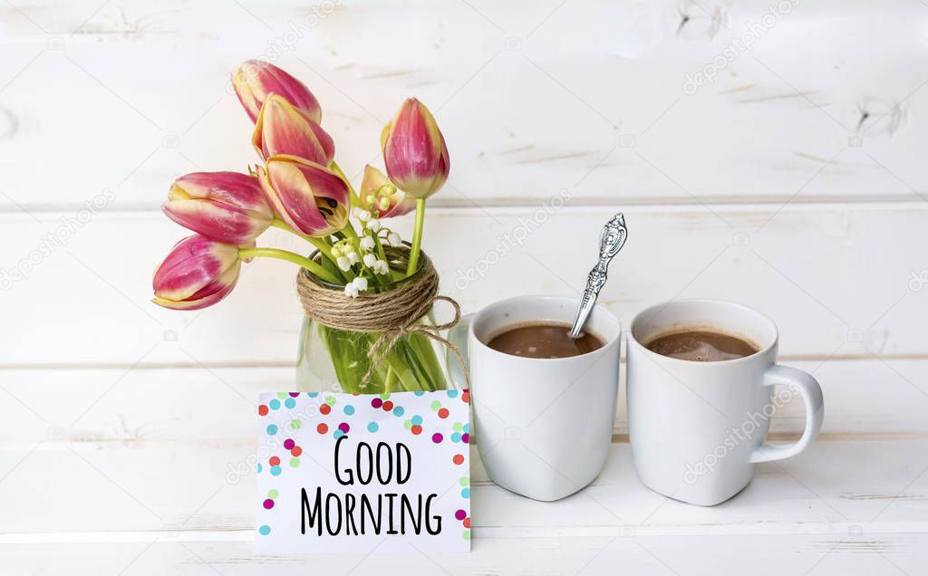 cups of aromatic coffee with tulips flowers and good morning  message 