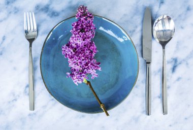 Bir mermer Background.Floral Masa desenli sofra Vintage mavi çatal ve Lila çiçeklerle bahar