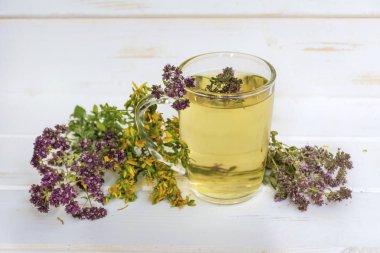 kurutulmuş papatya, kekik, kekik ve tutsan ile sağlıklı bitkisel çay fincan