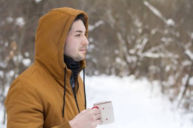 Genç adam kış dağda sıcak çay içme 