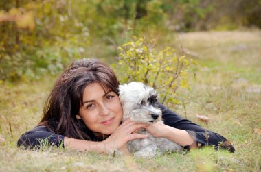 Güzel gülümseyen kadın onu sevimli Havanese köpek sarılma. Evde beslenen hayvan ve sahip açık