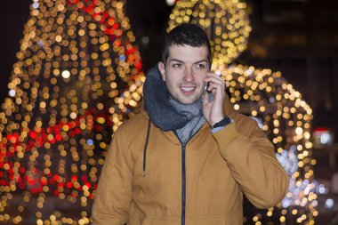 Chrismas ışıkları ile kentsel sokakta kış ceket yakışıklı genç adam 