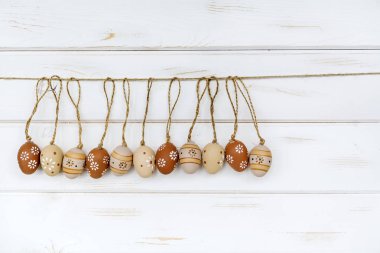 Beyaz ahşap zemin üzerinde bej bezemeli Paskalya yumurta 