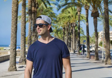 Gözlüklü yakışıklı adam yeşil avuç içi ile tropikal bir çare olarak onun tatil keyfini çıkarın