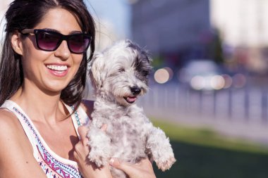 güzel kadın onun küçük sevimli beyaz köpek sokakta sarılma