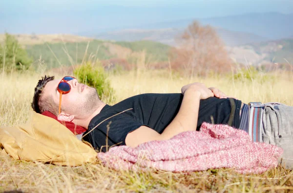 Sleeping man relaxing under sunlight in highlands
