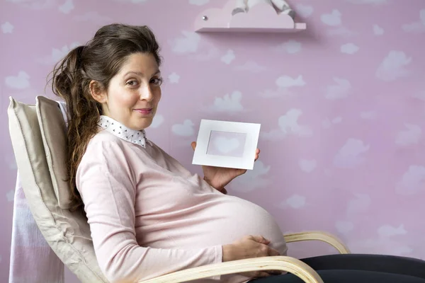 美しい妊娠中の女性が椅子に座っています 親と準備の概念 — ストック写真