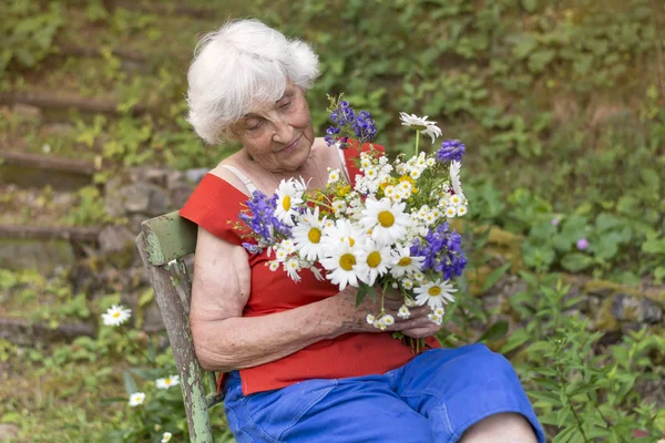 Mujer Mayor Sonriendo Sosteniendo Ramo Flores Las Manos — Foto de Stock