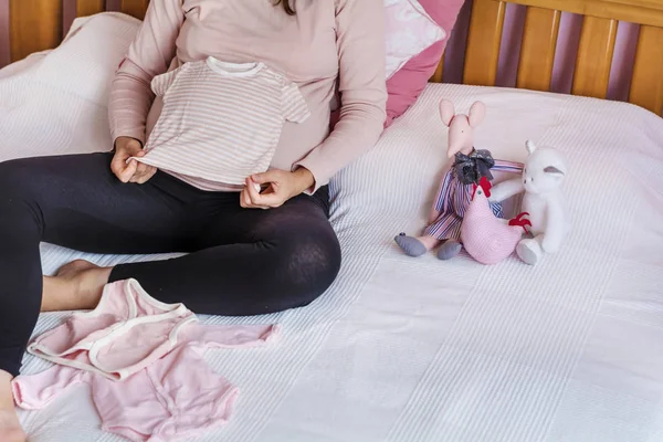 Imagen Recortada Mujer Embarazada Mostrando Ropa Bebé Casa — Foto de Stock