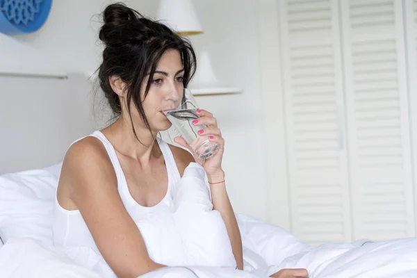 Beautiful Woman Drinking  Water in the Bed at the Morning.Healthy Start of the Day Concept