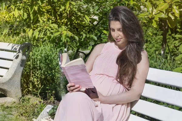 Счастливая Беременная Женщина Читает Скамейке Парке — стоковое фото