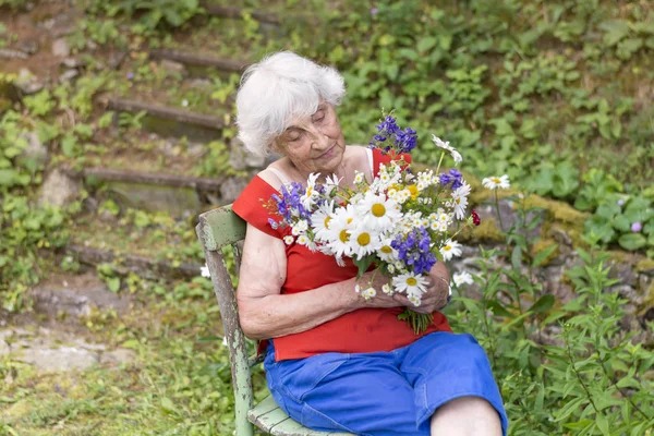 Mujer Mayor Sonriendo Sosteniendo Ramo Flores Las Manos — Foto de Stock