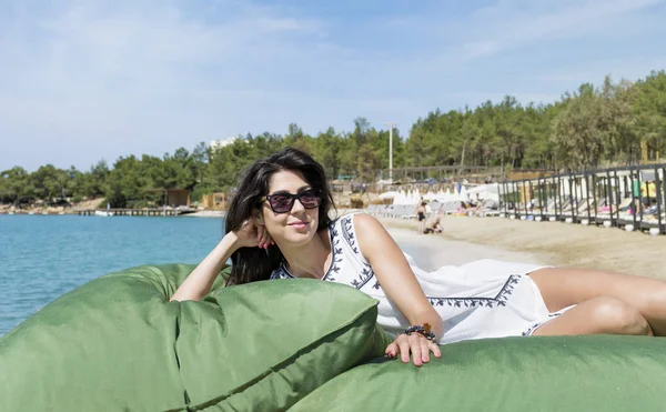 海の桟橋の上に大きな枕の上に座って美しい若い女性の肖像画 夏の休日 — ストック写真