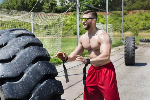 Büyük Bir Lastik Ile Genç Kaslı Adam Sokak Fitness Egzersiz — Stok fotoğraf