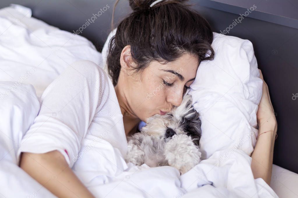 Woman Hugging her Sleeping Dog in the Bed