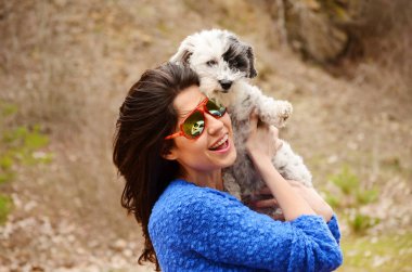 Güzel gülümseyen kadın onu sevimli Havanese köpek sarılma. Evde beslenen hayvan ve sahip açık