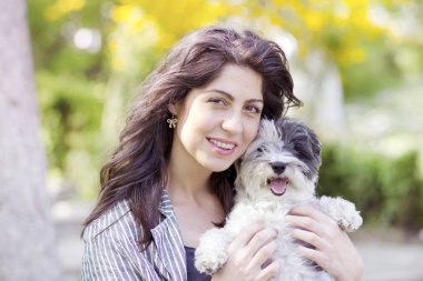 Güzel gülümseyen kadın onu sevimli Havanese köpek sarılma. Evde beslenen hayvan ve sahip açık