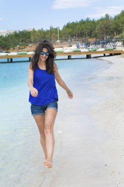 Genç kadının sahilde yürüyüş deniz manzaralı 