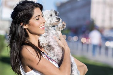 güzel kadın onun küçük sevimli beyaz köpek sokakta sarılma