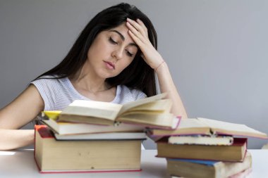 Yorgun ve üzgün öğrenci kadın kitaplar ile sınavları hakkında endişeli
